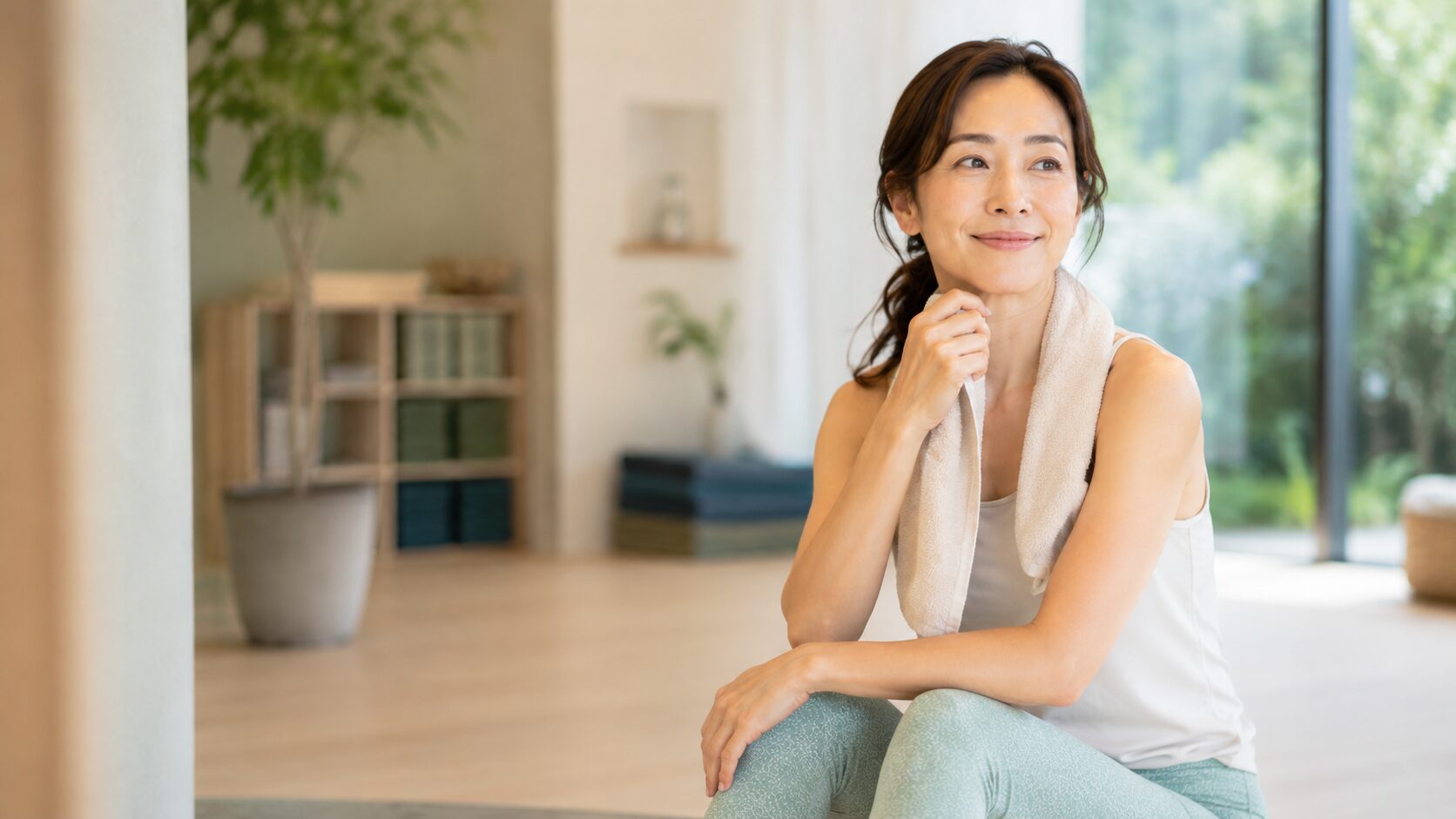 体験後タオルを首にかけてゆっくり考える女性